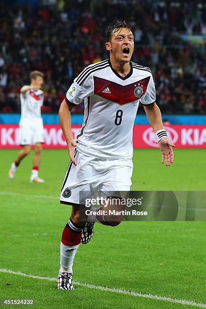 Mesut Oezil of Germany celebrates scoring his team's second goal in extra time during the 2014 FIFA World Cup Brazil Round of 16 match between...