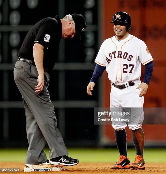 Jose Altuve of the Houston Astros takes a moment after stealing second base as umpire Tim Welke checks the base against the Seattle Mariners at...