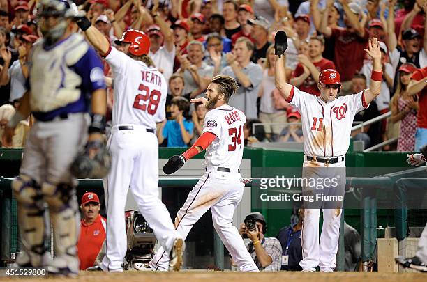 Bryce Harper, Jayson Werth and Ryan Zimmerman of the Washington Nationals celebrate after scoring in the sixth inning against the Colorado Rockies at...