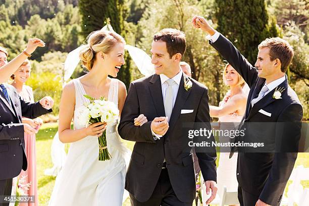 gäste werfen konfetti auf paar in hochzeit im freien - trauzeuge des bräutigams stock-fotos und bilder