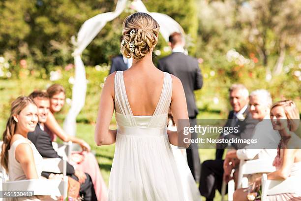 novia caminando por el pasillo durante ceremonia de bodas - novia fotografías e imágenes de stock