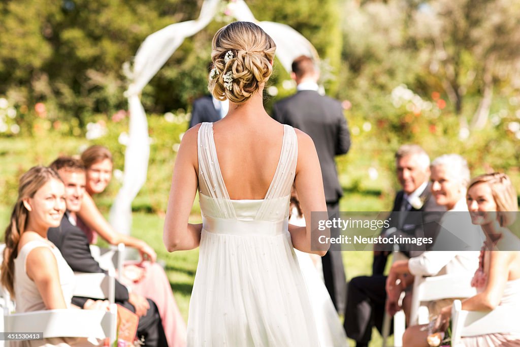 Bride Walking Down The Aisle During Wedding Ceremony