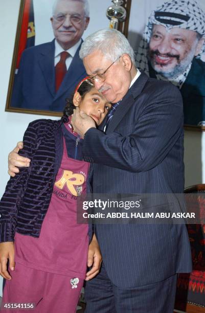 Palestinian Authority President Mahmud Abbas kisses 10-year-old Palestinian girl Huda Ghalya, whose father, mother and her three siblings were killed...