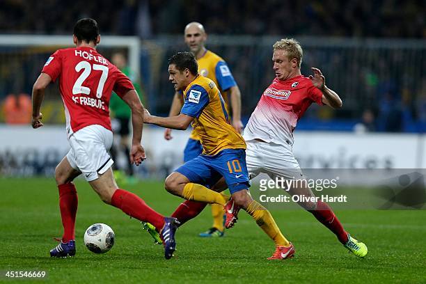 Mirko Boland of Braunschweig and Mike Hanke of Freiburg compete for the ball during the Bundesliga match between Eintracht Braunschweig and SC...