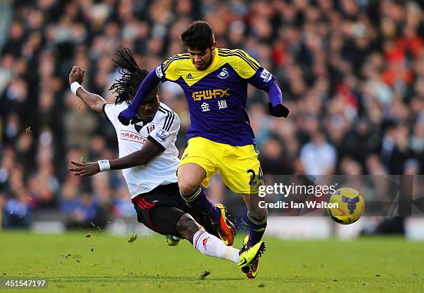 Alejandro Pozuelo of Swansea is tackled by Derek Boateng of Fulham during the Barclays Premier League match between Fulham and Swansea City at Craven...