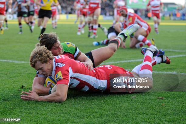 Billy Twelvetrees of Gloucester Rugby dives over to score a try despite the efforts of Luke Wallace of Harlequins during the Aviva Premiership Rugby...