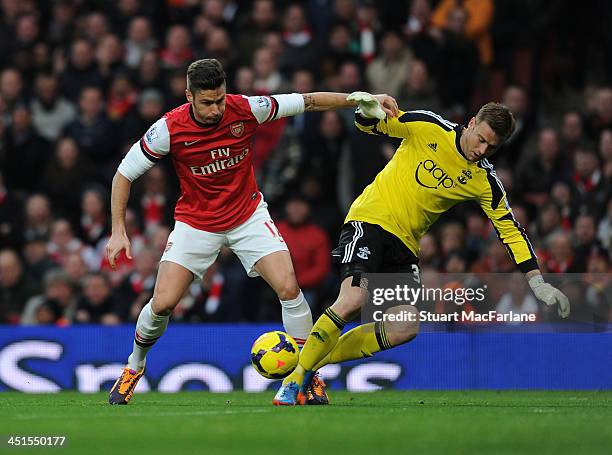 Olivier Giroud tackles Southampton goalkeeper Artur Boruc to score for Arsenal during the match at Emirates Stadium on November 23, 2013 in London,...