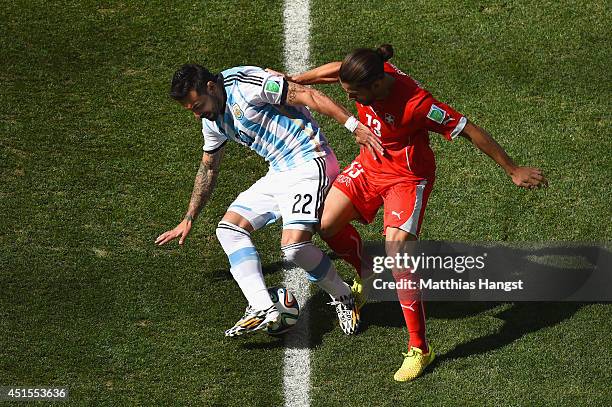 Ricardo Rodriguez of Switzerland challenges Ezequiel Lavezzi of Argentina during the 2014 FIFA World Cup Brazil Round of 16 match between Argentina...