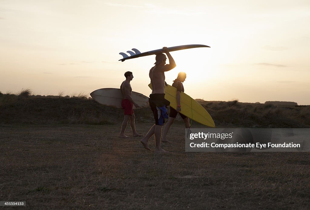 Surfers carrying boards