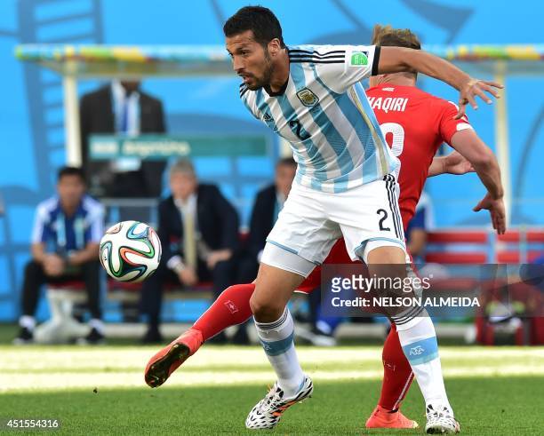 Argentina's defender Ezequiel Garay and Switzerland's midfielder Xherdan Shaqiri vie for the ball during a Round of 16 football match between...