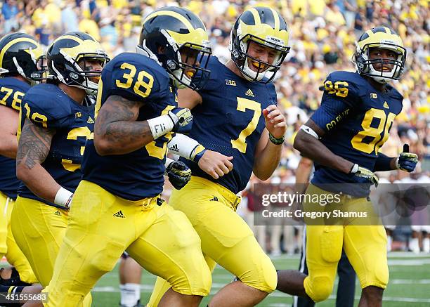 Thomas Rawls of the Michigan Wolverines celebrates his third quarter touchdown with Shane Morris while playing the Central Michigan Chippewas at...