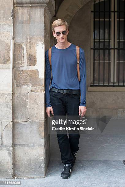 Model Paul Boche wearing vintage Ray Ban sunglasses and vintage bag, Nicholas K top, Rag and Bone jeans and New Balance trainers on day 1 of Paris...