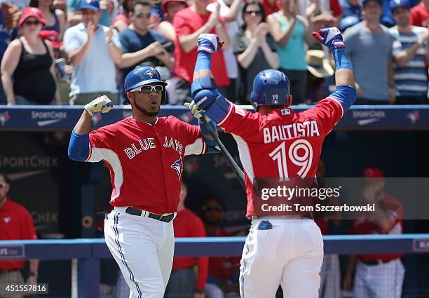 Jose Bautista of the Toronto Blue Jays celebrates with Edwin Encarnacion after hitting a solo home run in the first inning during MLB game action...