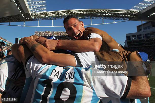 Angel di Maria of Argentina celebrates with teammates after scoring his team's first goal in extra time during the 2014 FIFA World Cup Brazil Round...