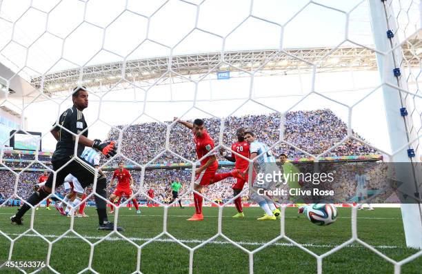Blerim Dzemaili of Switzerland heads the ball toward goal and hits the post as Sergio Romero of Argentina looks on during the 2014 FIFA World Cup...