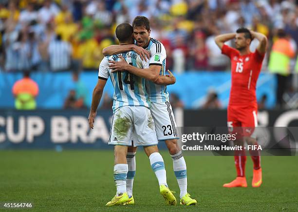 Javier Mascherano of Argentina celebrates with Jose Maria Basanta of Argentina as Blerim Dzemaili of Switzerland looks on after the 2014 FIFA World...