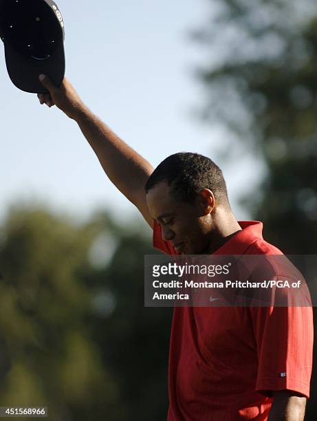 Tiger Woods tipping his hat to his fans after making his putt to win on green during round 4 of the 88th PGA Championship in Medinah, Illinois....