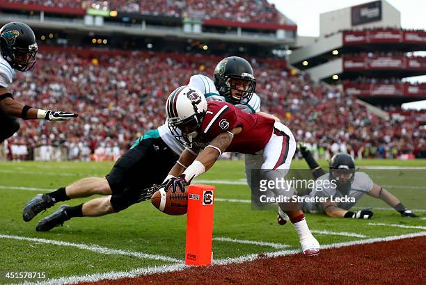 Richie Sampson of the Coastal Carolina Chanticleers tries to stop Damiere Byrd of the South Carolina Gamecocks from diving for a touchdown during...