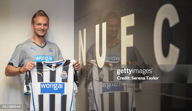 New signing Siem de Jong poses for photographs holding a Newcastle shirt in the home team dressing room at St.James' Park on July 01, 2014 in...