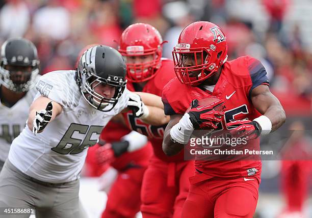 Running back Ka'Deem Carey of the Arizona Wildcats rushes the football past defensive tackle Taylor Hart of the Oregon Ducks during the college...