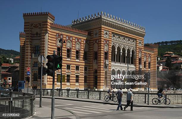 Peope walk past City Hall, called the Vijecnica and is the former National Library that was destroyed by Serbian shelling during the 1992-1995...