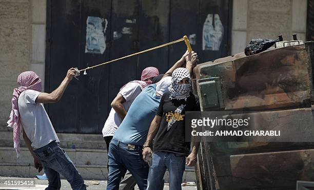 Palestinian protestors throw stones toward Israeli police during clashes in the Shuafat neighborhood in Israeli-annexed Arab East Jerusalem, on July...