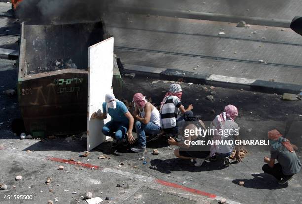 Palestinian protestors protect themselves during clashes with the Israeli police in the Shuafat neighborhood in Israeli-annexed Arab East Jerusalem,...