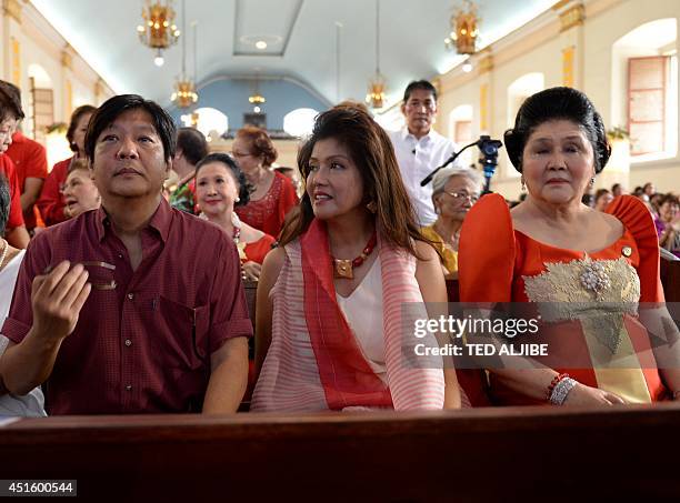 Philippine former first lady and now congresswoman, Imelda Marcos sits with her daughter governor Imee and Ferdinand Marcos Jr., as they attend mass...