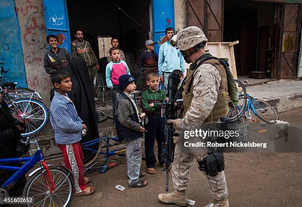 Iraqi children stare at a U.S. Marine patrolling February 17, 2007 in the Husayba, Iraq downtown market area. Husayba, a strategic border crossing...