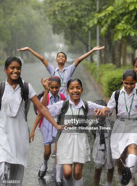 School children returning from school during the monsoon rain at
