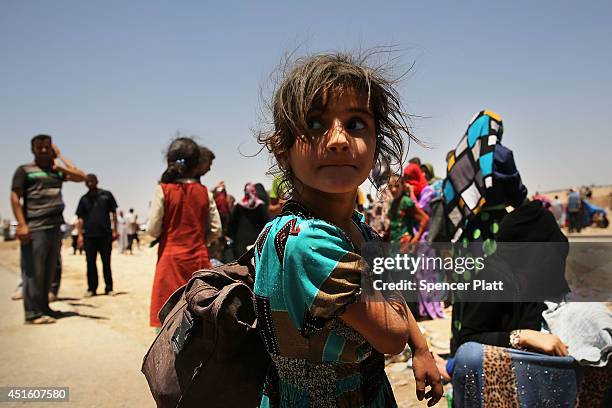 Iraqis who have fled recent fighting in the cities of Mosul and Tal Afar try to enter a temporary displacement camp but are blocked by Kurdish...