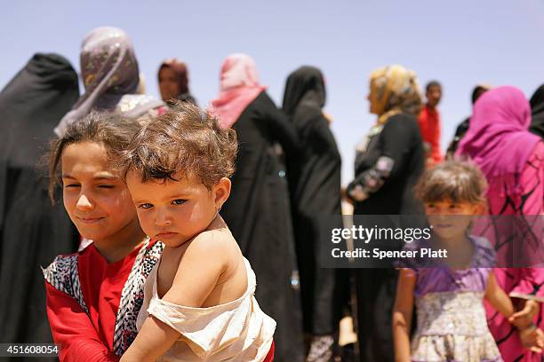 Thousands of Iraqis who have fled recent fighting in the cities of Mosul and Tal Afar try to enter a temporary displacement camp but are blocked by...