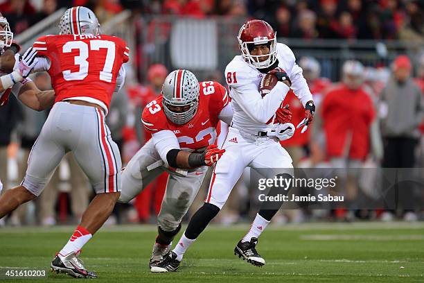 Duwyce Wilson of the Indiana Hoosiers spins off the tackle attempt of Michael Bennett of the Ohio State Buckeyes as Joshua Perry of the Ohio State...