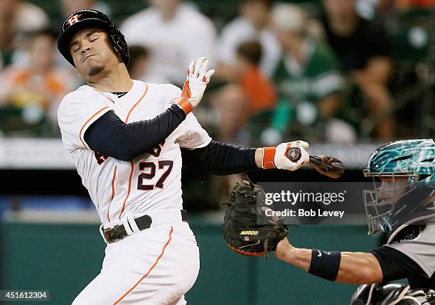 Jose Altuve of the Houston Astros strikes out in the first inning as catcher John Buck of the Seattle Mariners catches the ball at Minute Maid Park...
