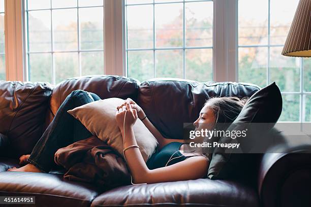 teenage girl listening to music - lying on back girl on the sofa stock pictures, royalty-free photos & images