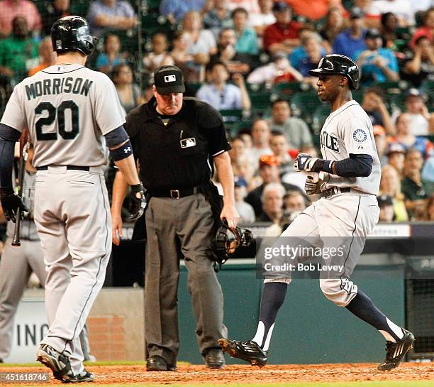 James Jones of the Seattle Mariners scores on a wild pitch in the sixth inning as Logan Morrison and home plate umpire Tim Welke looks on at Minute...