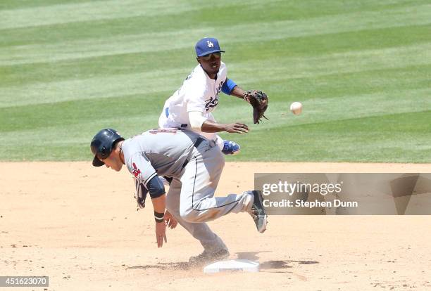 Second baseman Dee Gordon of the Los Angeles Dodgers collides with baserunner Yan Gomes of the Cleveland Indians after Gordon forced Gomes and threw...