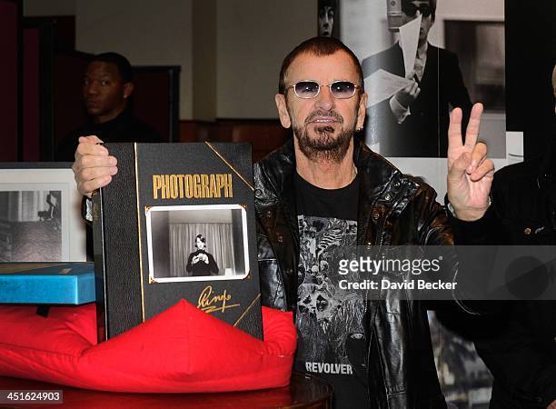 Recording artist Ringo Starr displays a copy of his book "Photograph" during an photo exhibition at the Palms Casino Resort on November 23, 2013 in...