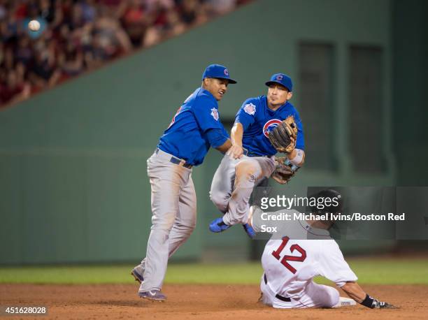 Starlin Castro of the Chicago Cubs tries to stay out of the way of Darwin Barney of the Chicago Cub as he attempts to complete a double play over...