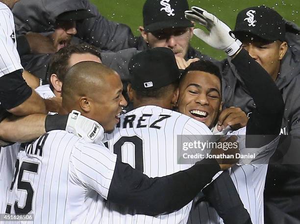 Leury Garcia of the Chicago White Sox is mobbed by teammates including Alexei Ramirez and Moises Sierra after hitting a game-winning, walk-off single...