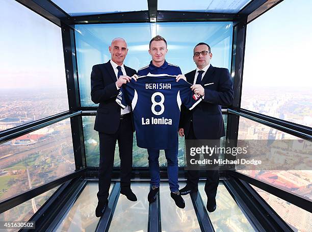 Victory recruit Besart Berisha poses with coach Kevin Muscat and chairman Anthony Di Pietro in front of the Melbourne city skyline during a Melbourne...