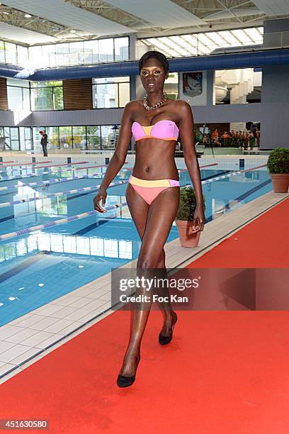 Model dressed by Laure Manaudou walks the runway during The 'Laure Manaudou Design' Swimming Suit show at Piscine Billancourt on July 2, 2014 in...