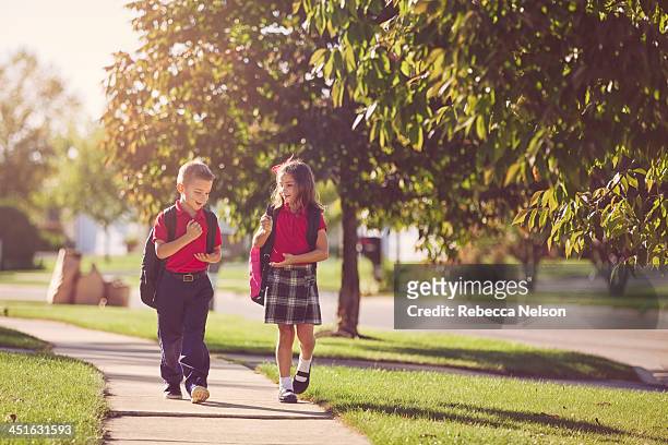 boy and girl walking home from school - boy and girl talking fotografías e imágenes de stock