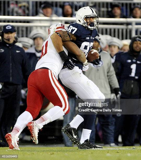 Nebraska's David Santos pulls down Penn State's Kyle Carter as he runs down the field with the ball at Beaver Stadium in University Park, Pa., on...