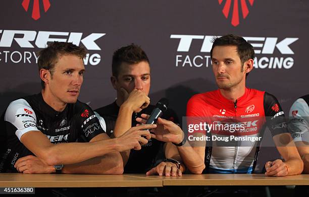 Andy Schleck of Luxembourg passes the microphone to his brother Frank Schleck of Luxembourg as Danny van Poppel of the Netherlands looks on as the...