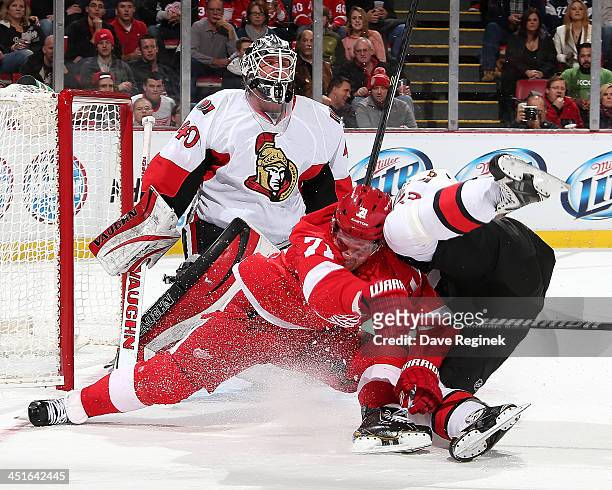 Goalie Robin Lehner of the Ottawa Senators looks over teammate Mika Zibanejad as he goes to the ice with Daniel Cleary of the Detroit Red Wings...