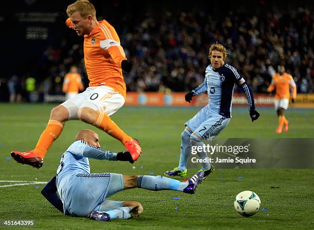 Aurelien Collin of the Sporting KC slide-tackles the ball away from Andrew Driver of the Houston Dynamo during Leg 2 of the Eastern Conference...