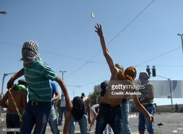 Palestinian youths throw stones at Israeli security forces during the clashes over the abduction and killing of a Palestinian teen by suspected...