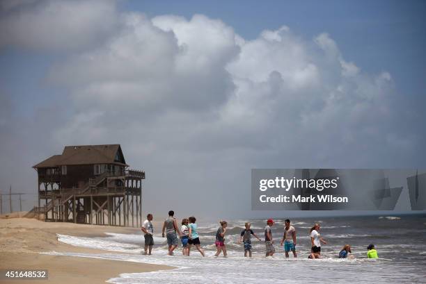 Members of the large Garrison family from Kansas City, MO., play in the surf before complying with the mandatory evacuation orders for Hatteras...