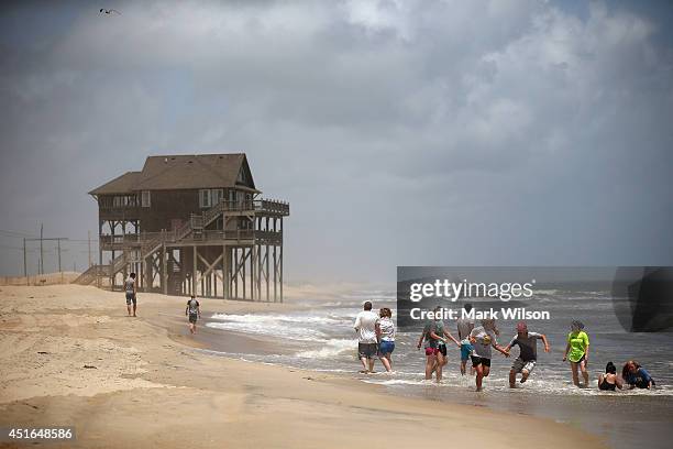 Members of the large Garrison family from Kansas City, MO., play in the surf before complying with the mandatory evacuation orders for Hatteras...